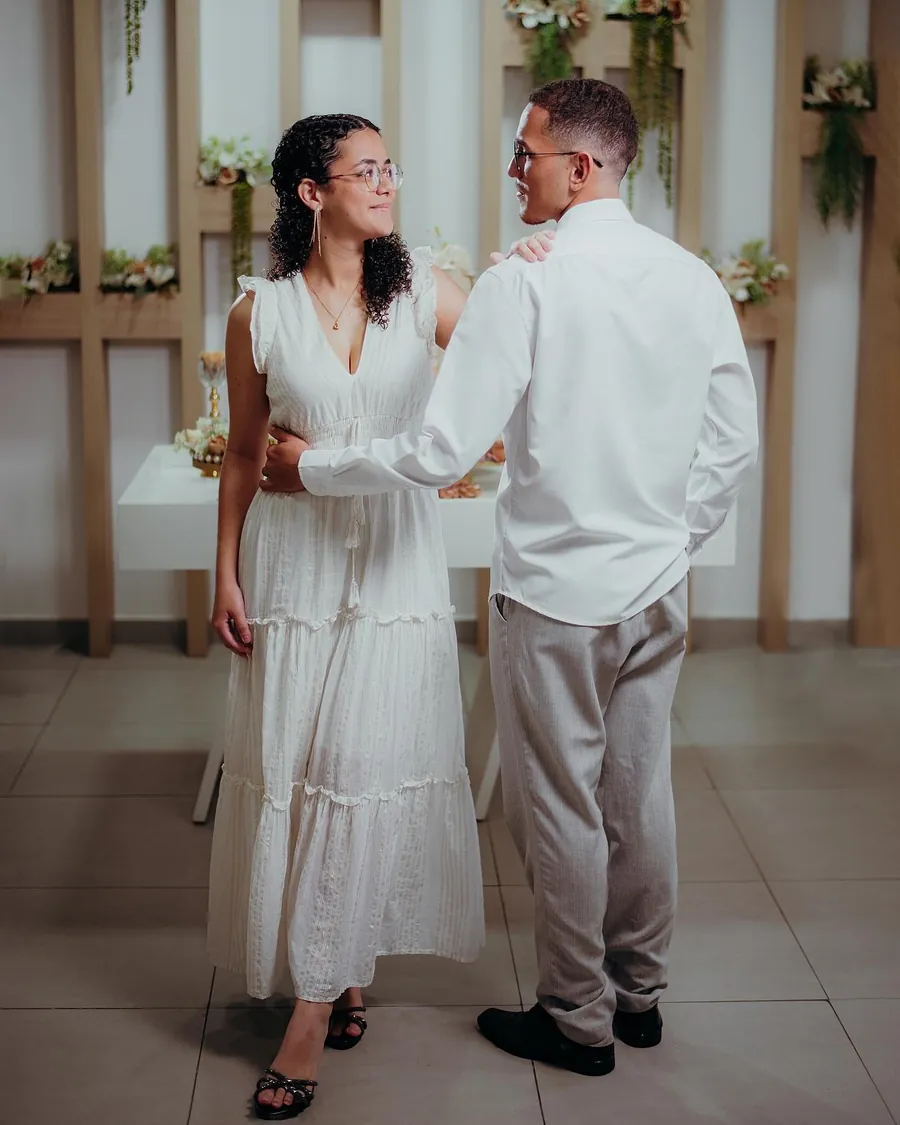 Noiva e noivo de mãos dadas no salão de casamentos